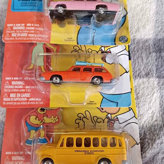 Unopened Simpsons diecast blister pack with yellow school bus and red car
