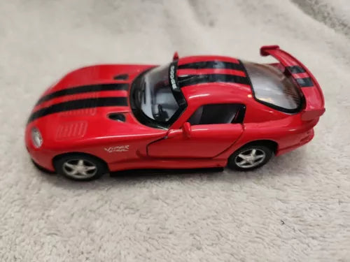 Red 1:36 diecast sports car model with black racing stripes, side view