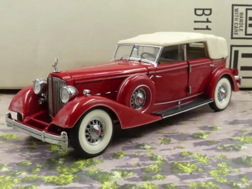 Red and white 1934 Packard sedan diecast, 1:24 scale, front three-quarter view