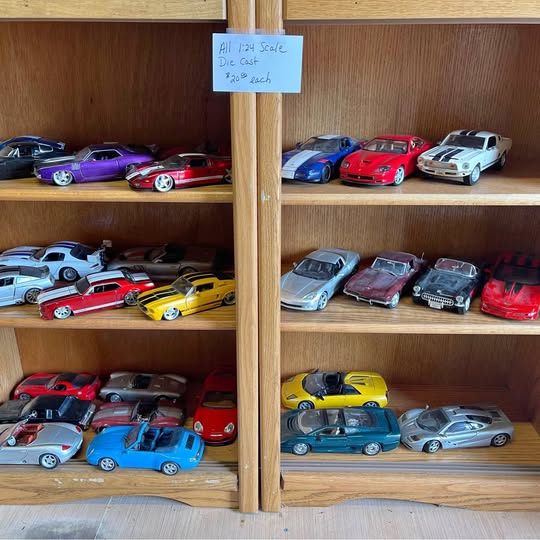 Diecast scale model cars, mixed colors, on display shelf