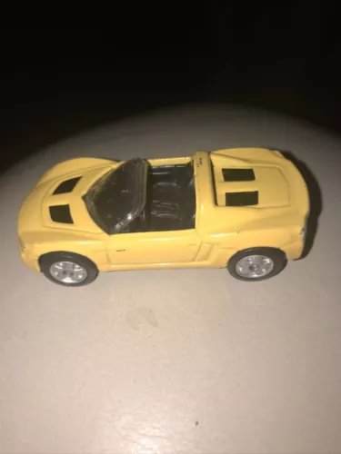 Yellow 1:64 convertible diecast car with black roof, side view