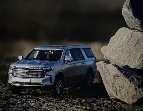 Diecast SUV sports model toy, dark blue-gray, front three-quarter view, 1:64 scale.