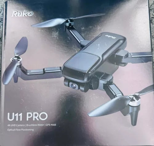 Foldable remote control camera drone with dark gray body and four prop blades