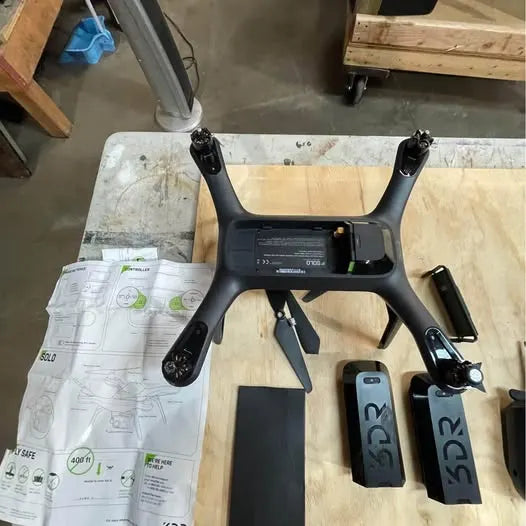Black quadcopter drone with four arms and attached camera mount