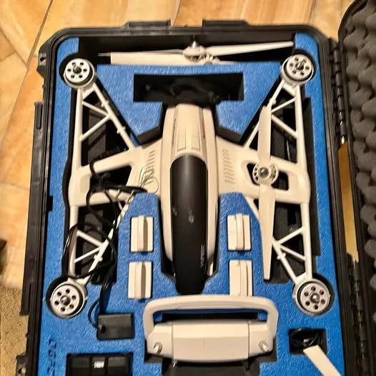Drone kit with white arms and black central body in protective case