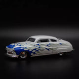 1:64 diecast model car, white with blue flames, front three-quarter view.