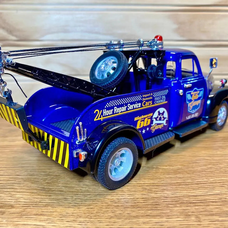 Welly 1:24 diecast tow truck model in blue with black details, front and side view