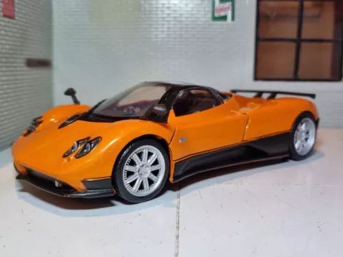 Orange supercar diecast model, front 3/4 view, black wheels and side vents.
