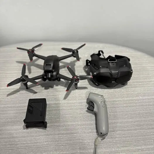 FPV drone with four rotors and remote controller, black with gray handset