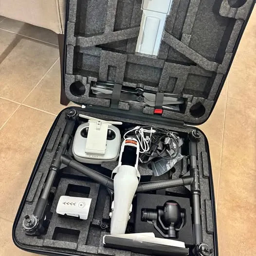 Foldable drone and accessories in open hard case, central remote controller
