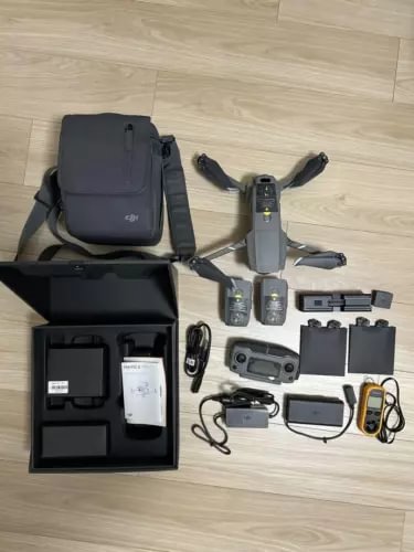 Camera drone kit with folded drone, controller, batteries, charger, cables, and carrying bag