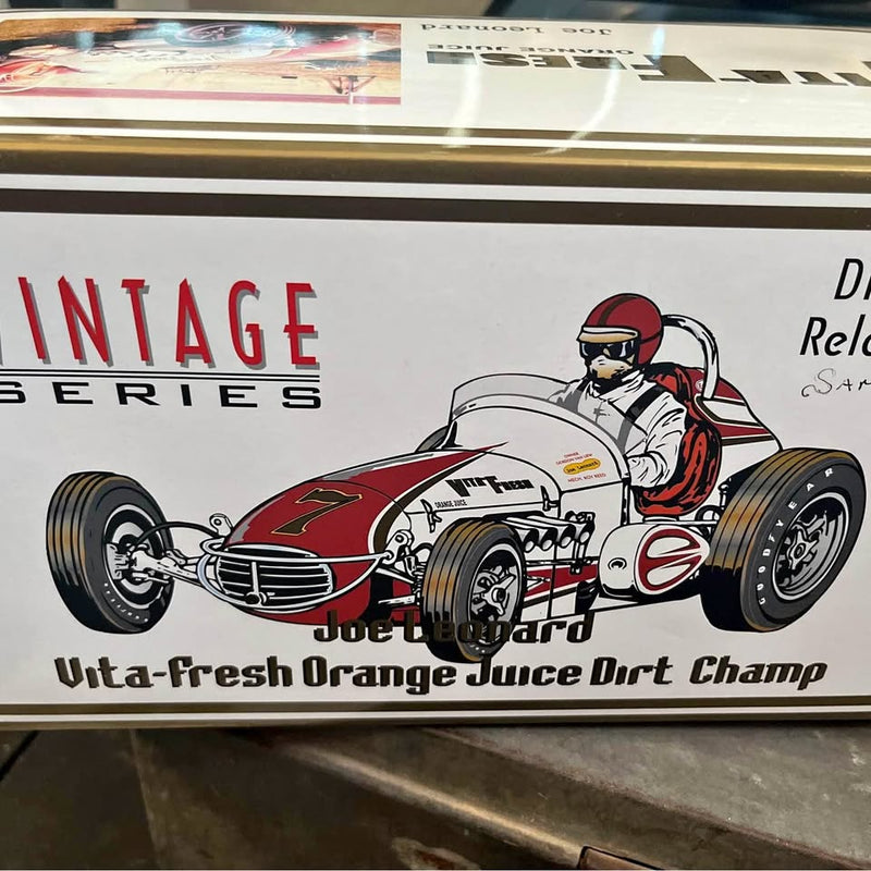 Vintage diecast race car with red and white body, open cockpit driver figure