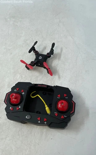 Mini drone with remote controller, black and red, shown powered on