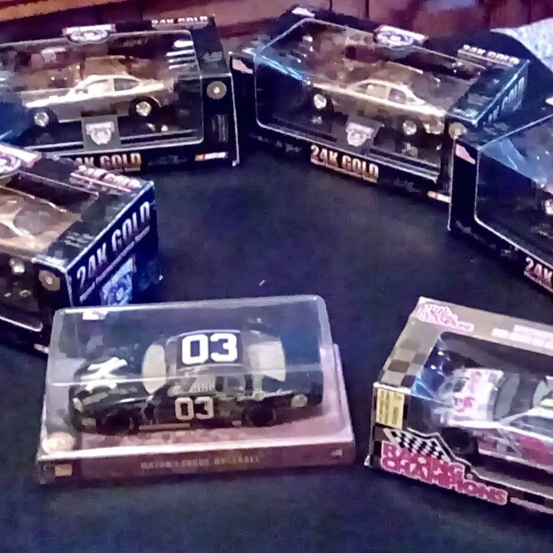 Boxed 1/24 diecast model cars with black vehicles, number 03 on clear windows