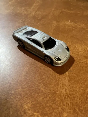 Hot Wheels diecast sports car, silver body with black windows and hood vents