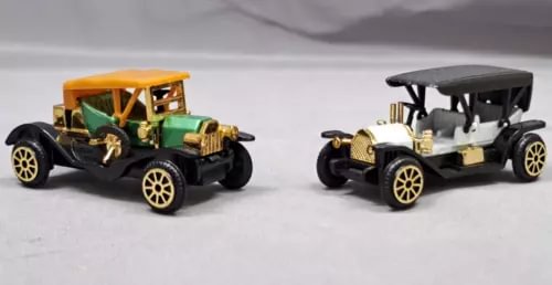 Vintage diecast classic cars, green open-top and black open-top, pair