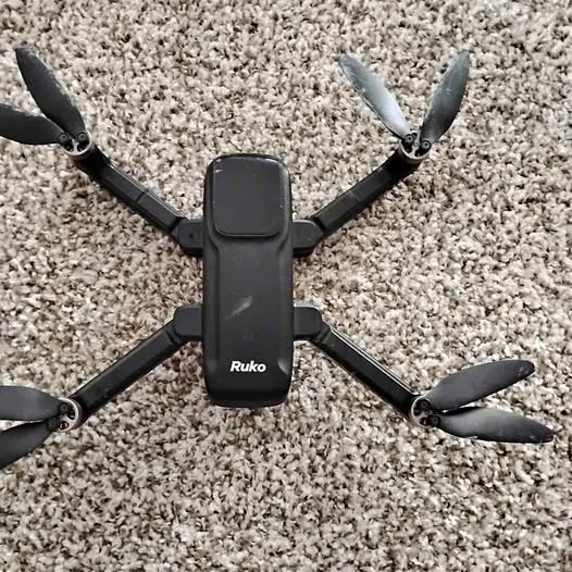 Black quadcopter drone with four propellers and central control module