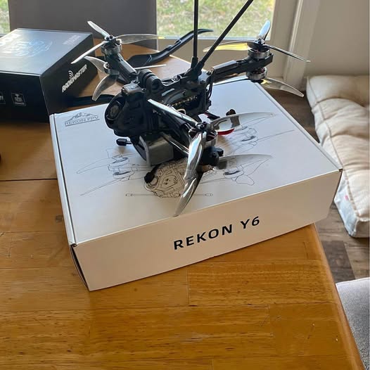Rekon Y6 drone resting on shipping box, with four propellers and camera mount