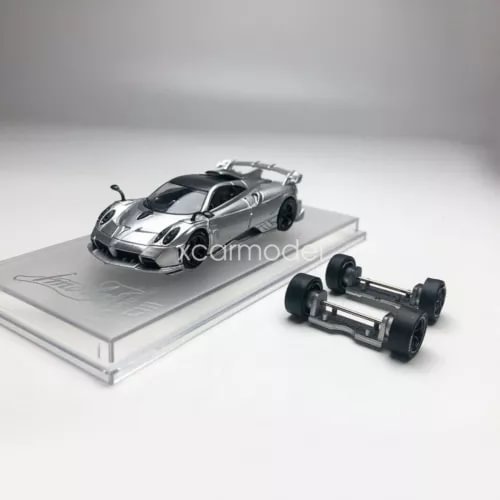 Silver diecast sports car model on display base with separate wheel assembly