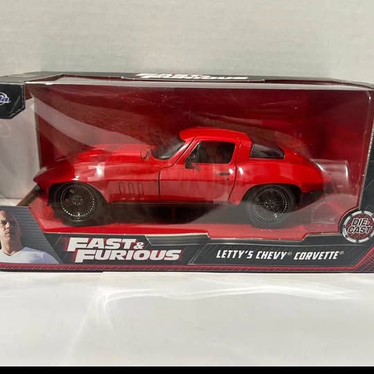 Red diecast sports car model in collector display box