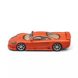 Orange 1:43 diecast sports car model with open cockpit and side profile.
