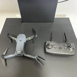 Gray quadcopter drone with four propellers and remote controller