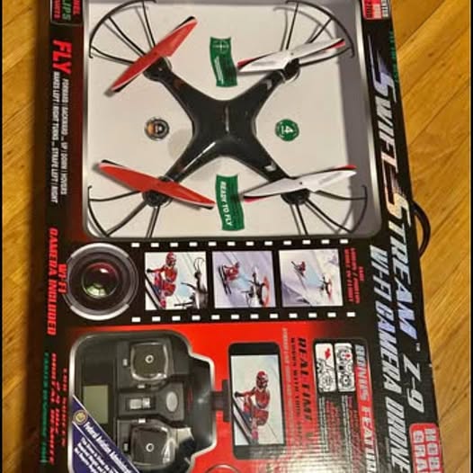 Toy quadcopter drone kit with camera module and propellers, in box