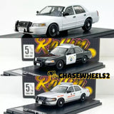 White police diecast sedan with black grille and wheels, front 3/4 view