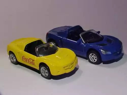 Pair of diecast miniature cars, yellow and blue with Coca-Cola decals, loose.