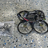 Black cineFPV drone with 4 propellers, exposed motors and wiring on top frame.