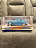 Blue hard-top diecast car in clear display box, with Dinky branding on base.