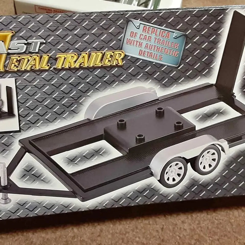 Black diecast car trailer with dual wheels and textured diamond-plate bed
