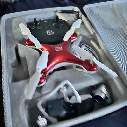 Red and white quadcopter drone with four rotors in storage case