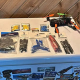 Multirotor drone with orange arms and boxed spare parts in plastic bags