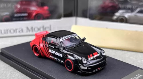 Racing diecast model car, black with red decals and red wheels, front 3/4 view