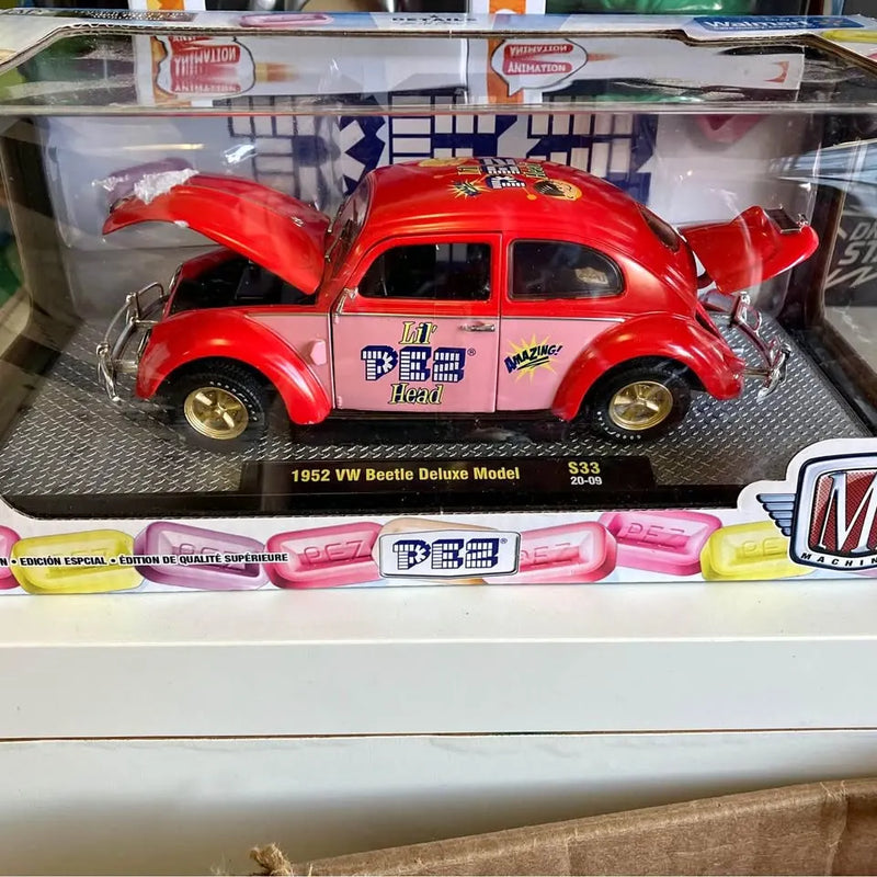 Red diecast VW Beetle model car with hood open, classic styling and gold wheels