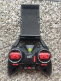 Black drone remote control with phone holder, red buttons, and green power light