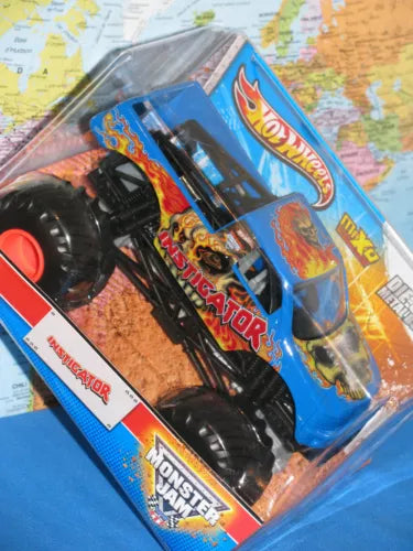 Blue blister-packaged Monster Jam die-cast truck with black wheels and red stripe