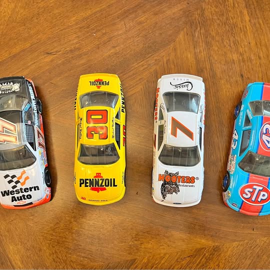 Set of four 1:24 NASCAR metal diecast race cars in yellow, white, blue, black