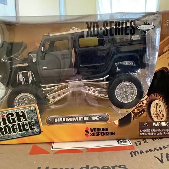 Boxed 1:24 diecast truck model with working suspension, dark gray and blue