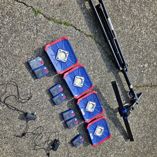 Cordless LED work lights kit with red-blue lights, battery packs, and tripod pole
