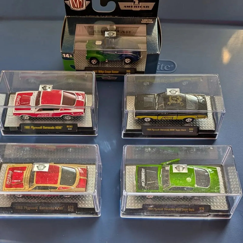 Set of 1:64 diecast cars in clear display cases, red and dark green