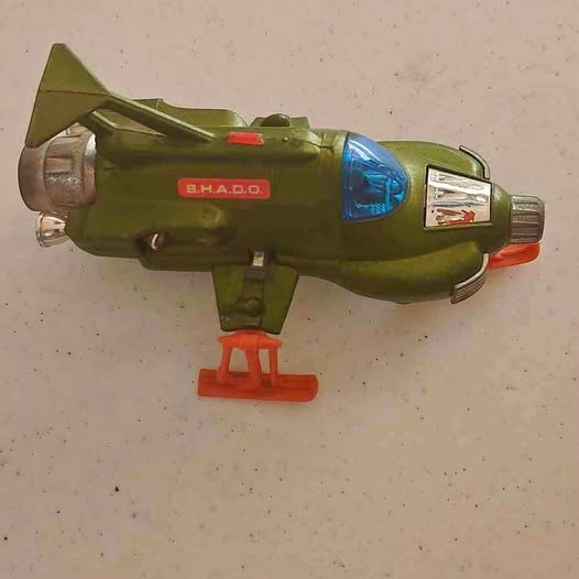 Olive green diecast airplane toy with blue nose light and propeller