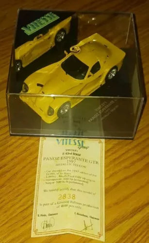 Yellow 1:43 diecast race car model in clear display box with paper certificate