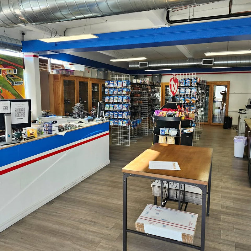 Diecast toy display at a retail counter with hanging racks and boxed models