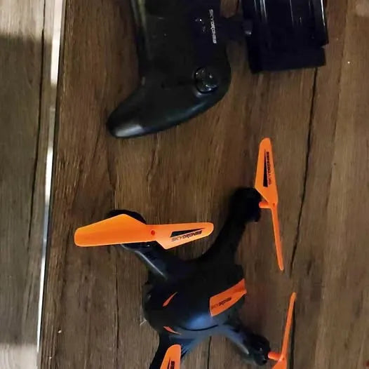 Foldable quadcopter drone with camera, orange and black with propeller guards