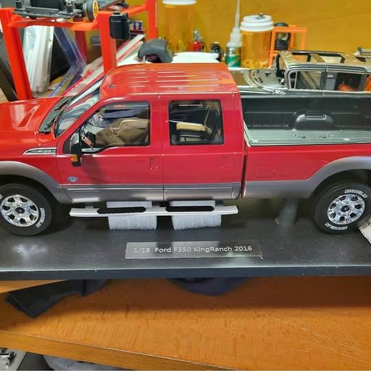 Red and gray diecast Ford F-350 pickup with side steps, chrome wheels, bed detail