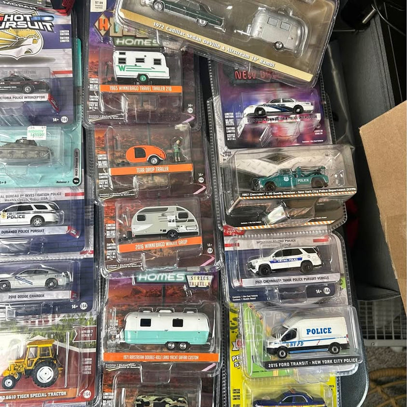 Diecast car sets in retail blister packaging, mixed police and vintage cars