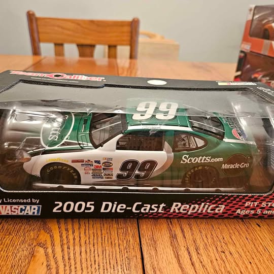 Die-cast replica race car in retail box, green with #99 on hood
