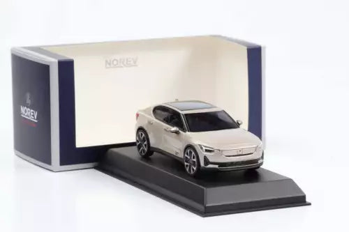 Diecast car model with light gray body, displayed in open box on black base